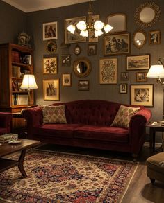 a living room filled with furniture and lots of framed pictures on the wall above it