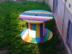 a multicolored wooden bench sitting in the grass