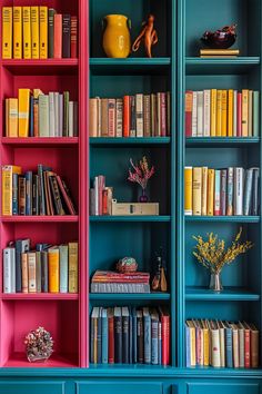 the bookshelves are painted bright pink and blue, with yellow vases on each shelf