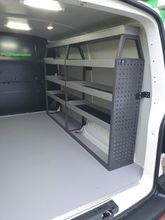 the back end of a white van with shelves in it