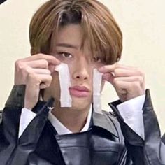 a young man holding two pieces of paper in front of his face