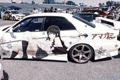 a white car parked in a parking lot covered in snowflakes and anime characters