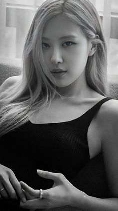 black and white photograph of a woman sitting on a couch with her hand in her pocket