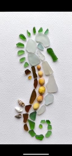 sea glass and seashells are arranged in the shape of a man's head