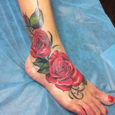 a woman's foot with red roses on it