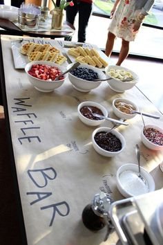 people are standing around a table with food on it