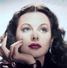 an old photo of a woman with her hand on her chin and looking at the camera