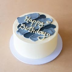 a birthday cake with the words happy birthday written on it and frosting in blue