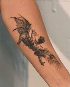 a tattoo on the arm of a woman with a dragon flying over her head,
