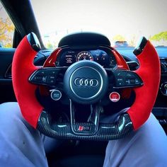 the interior of an audi car with red and black steering wheel covers