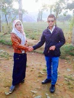 two people holding hands on a dirt path