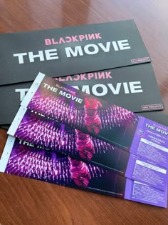 three movie tickets sitting on top of a wooden table