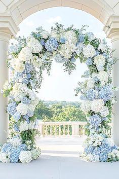 an archway decorated with blue and white flowers