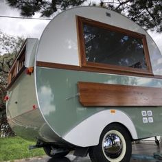 an old camper trailer is parked on the side of the road
