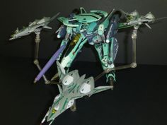 a green and white model airplane on a black surface