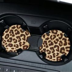 two leopard print hair clips are attached to the dashboard of a car with steering wheel controls