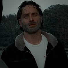 a man in a black jacket looking at another man