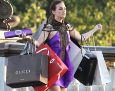 a woman holding shopping bags and pointing at something