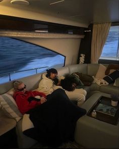 three people sitting on a couch in front of a window