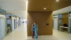 two people hugging each other in an office hallway
