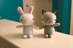 two stuffed animals sitting on top of a counter