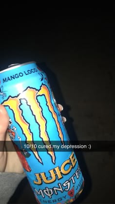 a person holding up a can of juice