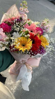 a bouquet of flowers tied to the handle of a scooter