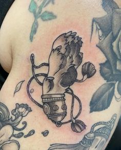 a close up of a person's chest with tattoos on it and flowers in the background