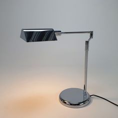 a chrome plated desk lamp with a marble base and dimmer on the side