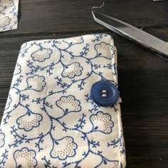 a pair of scissors sitting on top of a table next to a piece of cloth