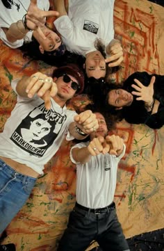 a group of young people standing next to each other with their hands in the air