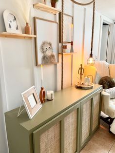 a living room with green furniture and pictures on the wall above it, along with other decor items