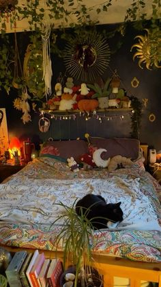 a black cat laying on top of a bed in a room with plants and decorations