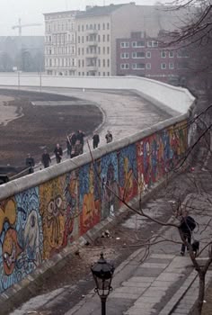 people are walking on the side of a wall