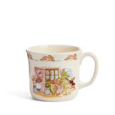 a coffee cup with an image of animals and people on the outside, in front of a window
