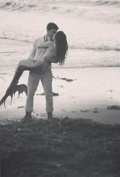a man holding a woman on the beach