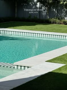 an empty swimming pool with grass around it