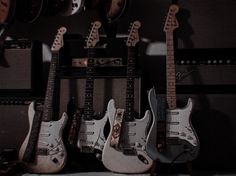 guitars and amps are lined up against the wall