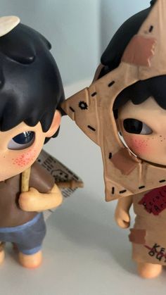 two toy figurines that look like they are holding something in their hands and looking at each other