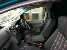 the interior of a car with grey and red seats
