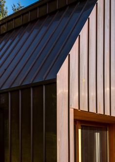 the side of a building with a cat sitting on it's window sill