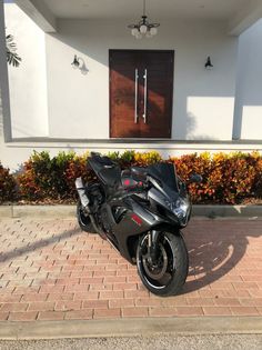 a black motorcycle parked in front of a house