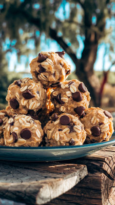 chocolate chip cookies stacked on top of each other in front of a wooden table outdoors