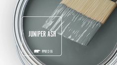 a paint can with a brush in it and the words juniper ash painted on it