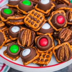 a white plate topped with lots of pretzels covered in chocolate and candies