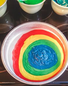 a bowl filled with rainbow cake batter on top of a stove