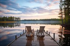 Wooden dock with empty chairs overlooking a serene lake stock photo