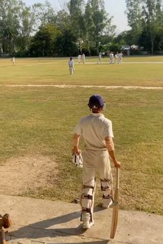 a man holding a baseball bat on top of a field