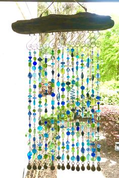 a wind chime hanging from the side of a window with lots of beads on it