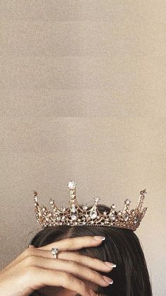 a woman wearing a tiara covering her face
